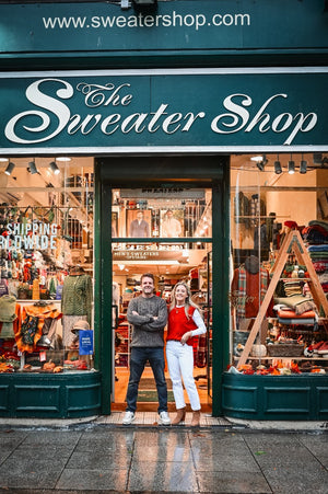 outside_shop Paul and Laura and a range of aran sweaters and other knitwear items  